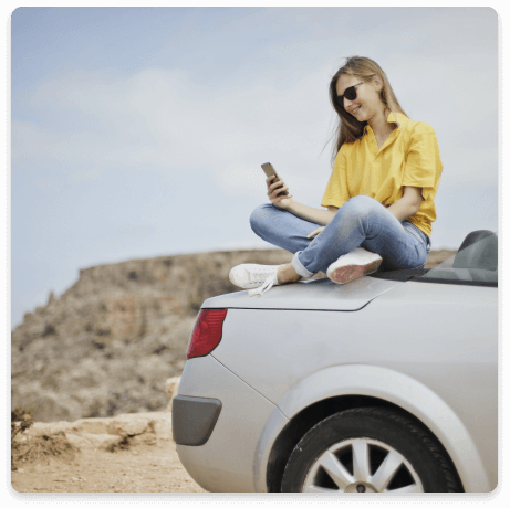 Young Woman driver reading car insurance cover information while stranded